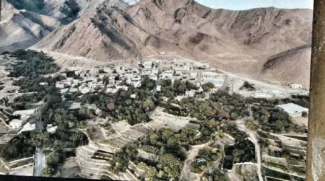 نمای روستا و باغ‌ها از بالا در پای کوه‌های سنگی و پرشیب